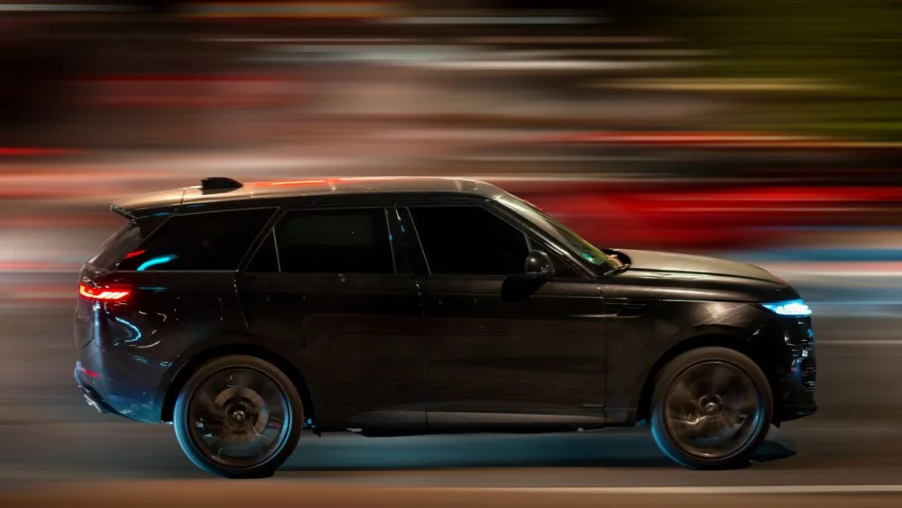 Black executive SUV in motion at night