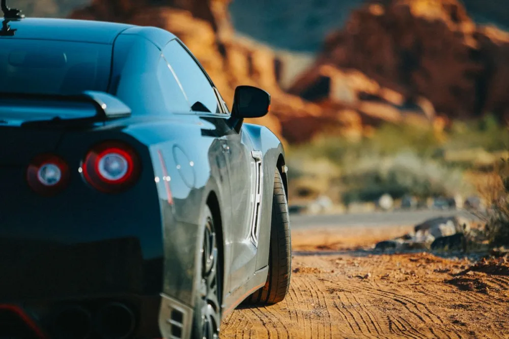 Exotic sports car against red desert rock formations