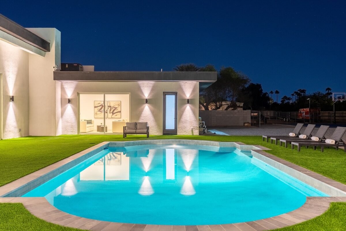 Crystal-clear swimming pool lit at night at private Scottsdale golf villa sleeps 14